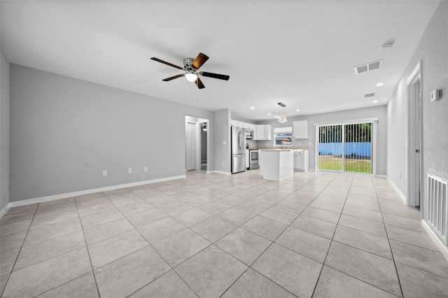 unfurnished living room featuring ceiling fan and light tile patterned floors