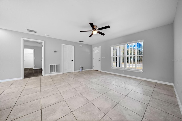 empty room with ceiling fan and light tile patterned flooring