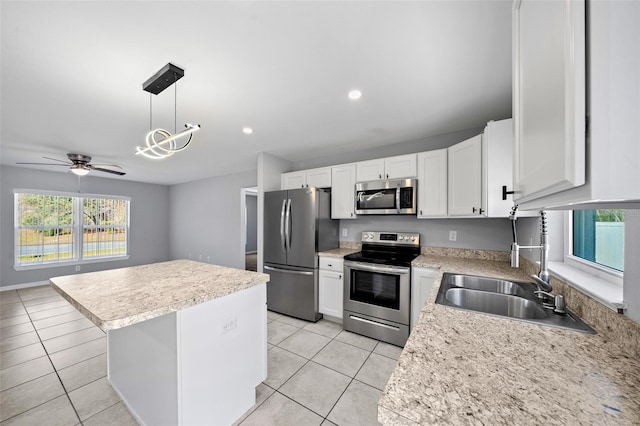 kitchen with hanging light fixtures, light tile patterned floors, appliances with stainless steel finishes, and white cabinetry