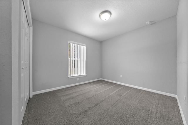 empty room with dark colored carpet