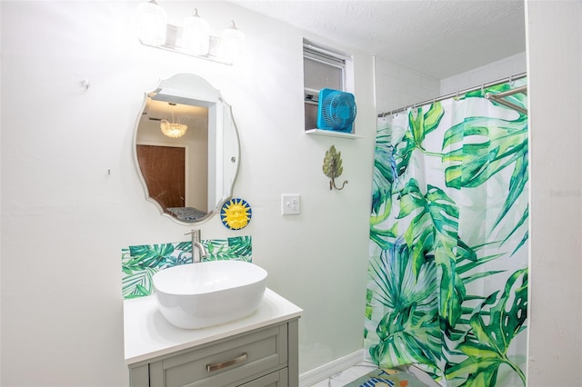 bathroom with vanity, curtained shower, and a textured ceiling