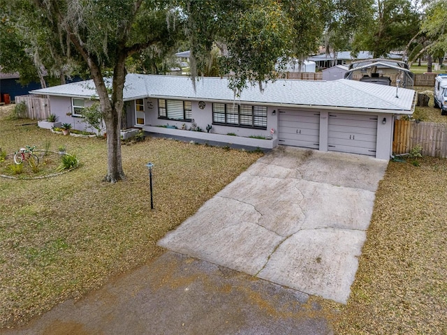 ranch-style house featuring a garage and a front lawn