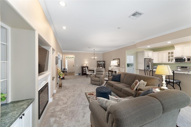 carpeted living room featuring ornamental molding and a chandelier