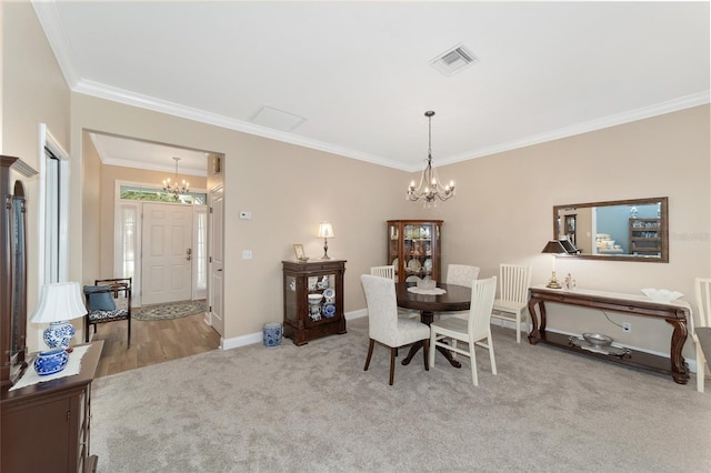 carpeted dining room with ornamental molding and a notable chandelier