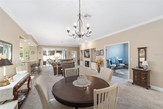 dining room featuring ornamental molding, light carpet, and an inviting chandelier