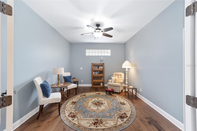 sitting room featuring dark wood-type flooring and ceiling fan