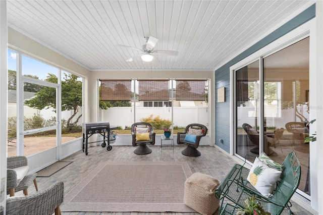 sunroom with ceiling fan, a wealth of natural light, and wood ceiling