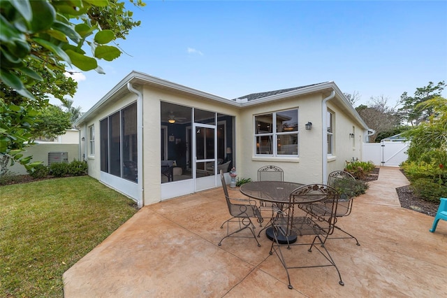 back of property featuring a patio, a sunroom, and a yard