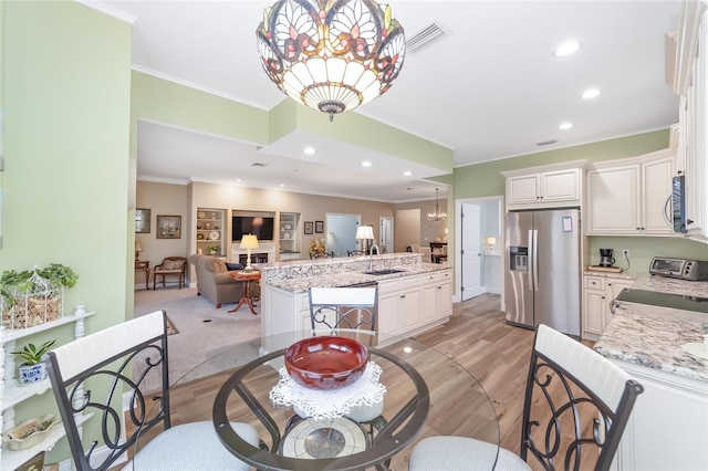 dining space featuring recessed lighting, a chandelier, light wood-style flooring, and ornamental molding