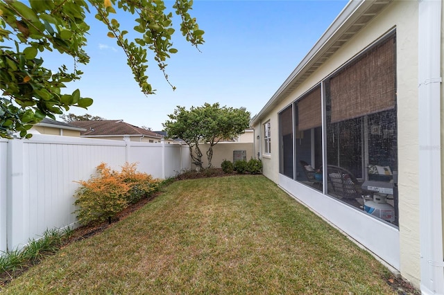 view of yard with a sunroom and a fenced backyard