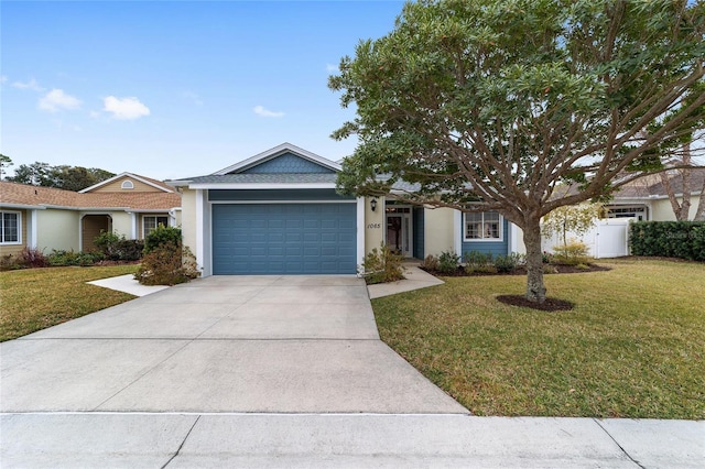 single story home with stucco siding, an attached garage, fence, driveway, and a front lawn