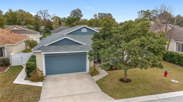 view of front facade featuring roof with shingles, an attached garage, a gate, driveway, and a front lawn