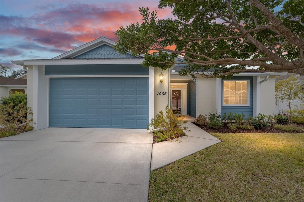 1065 NE 31st Ter, Ocala, FL 34470 - view of front of property featuring concrete driveway, a front lawn, stucco siding, and a garage