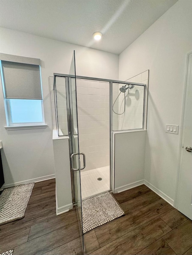 bathroom with an enclosed shower and wood-type flooring