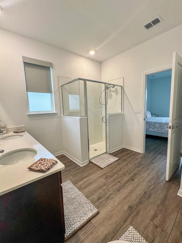 bathroom featuring vanity, a shower with shower door, and a textured ceiling