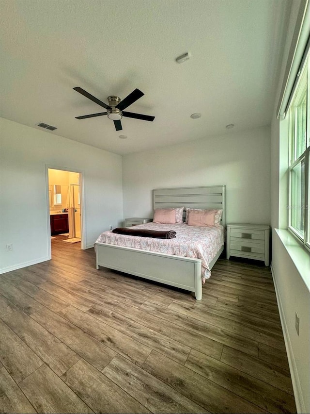 unfurnished bedroom featuring a textured ceiling, hardwood / wood-style floors, ensuite bathroom, and ceiling fan