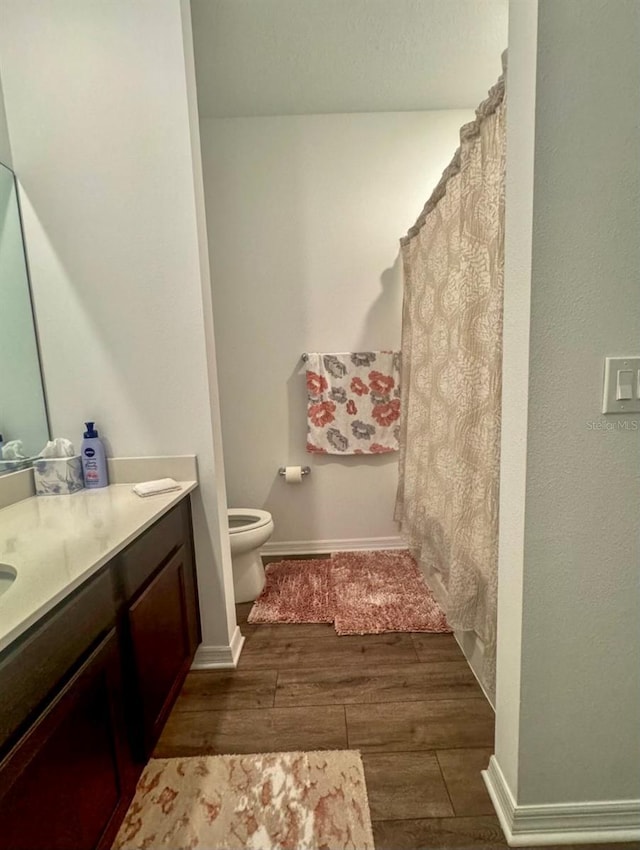 bathroom featuring hardwood / wood-style floors, toilet, and vanity