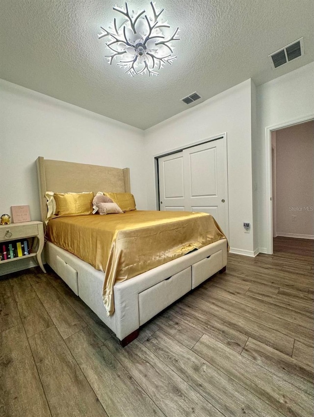 bedroom featuring wood-type flooring and a textured ceiling