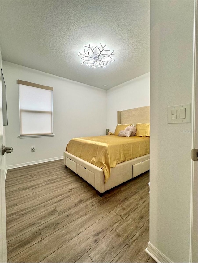 bedroom featuring wood-type flooring and a textured ceiling