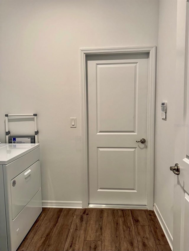 clothes washing area with dark hardwood / wood-style flooring and washer / clothes dryer