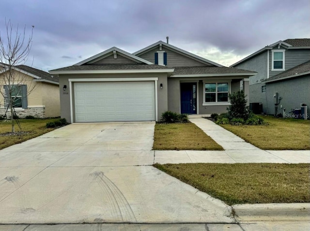 view of front of property with a garage, a front yard, and central AC