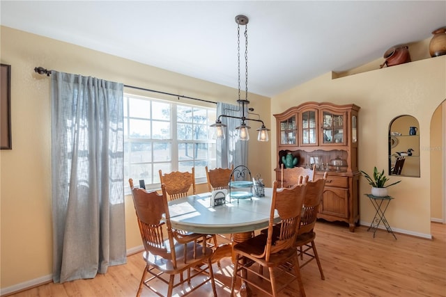 dining space featuring vaulted ceiling and light hardwood / wood-style flooring