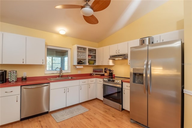 kitchen with sink, white cabinetry, vaulted ceiling, stainless steel appliances, and light hardwood / wood-style floors