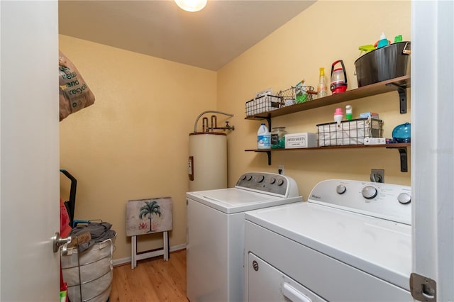 laundry room featuring water heater, washer and dryer, and light hardwood / wood-style floors