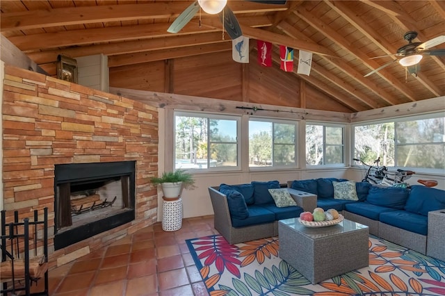 sunroom / solarium featuring ceiling fan, plenty of natural light, and a fireplace