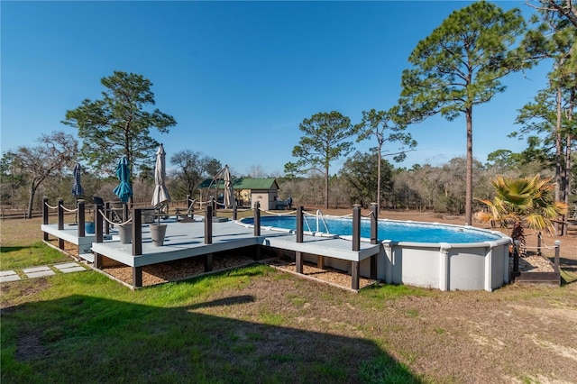 view of swimming pool featuring a wooden deck and a lawn