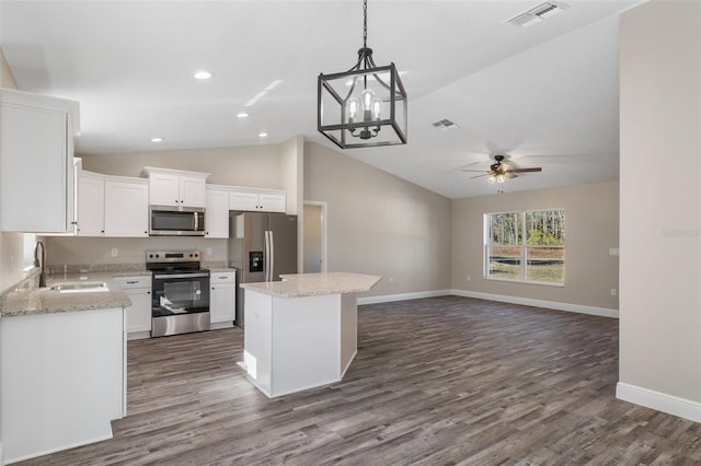 kitchen featuring sink, a center island, vaulted ceiling, appliances with stainless steel finishes, and white cabinets