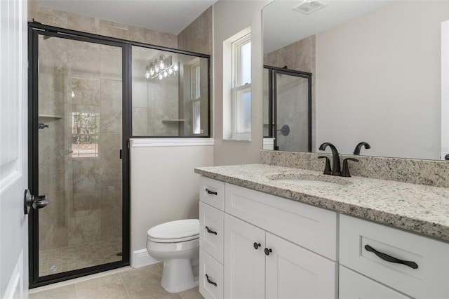 bathroom featuring tile patterned flooring, vanity, a shower with door, and toilet