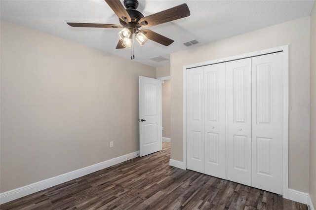 unfurnished bedroom featuring dark hardwood / wood-style flooring, a textured ceiling, a closet, and ceiling fan