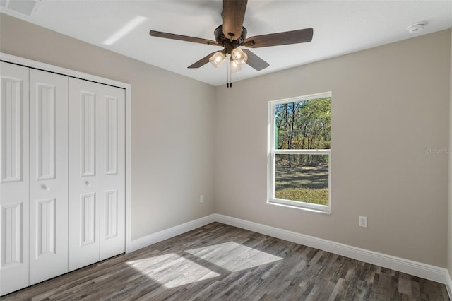 unfurnished bedroom with ceiling fan, hardwood / wood-style floors, and a closet