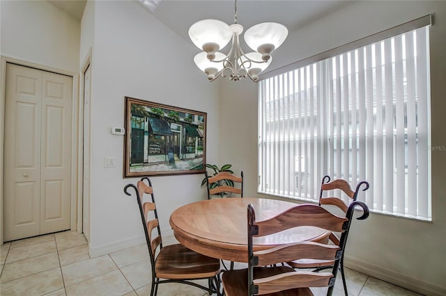 dining room with vaulted ceiling, light tile patterned floors, and an inviting chandelier