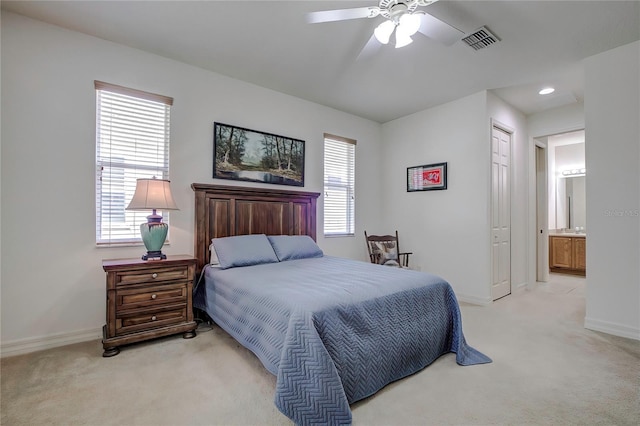 bedroom with a closet, ceiling fan, connected bathroom, and light colored carpet