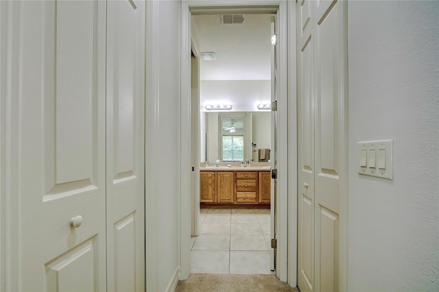 corridor with sink and light tile patterned flooring