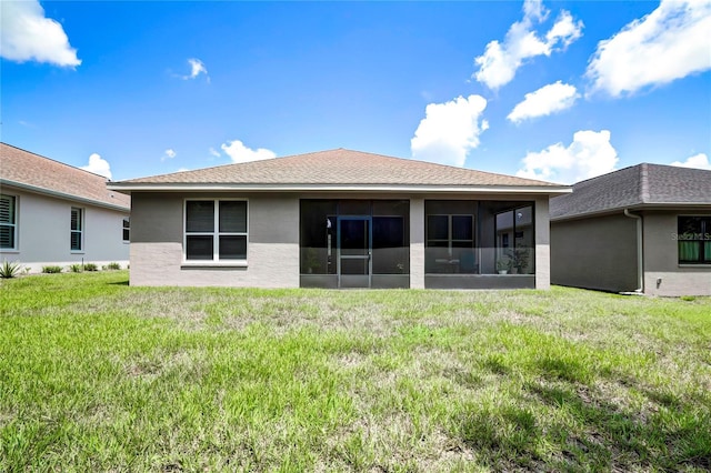 rear view of property with a lawn and a sunroom