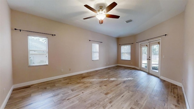 empty room featuring light wood-type flooring, ceiling fan, and french doors