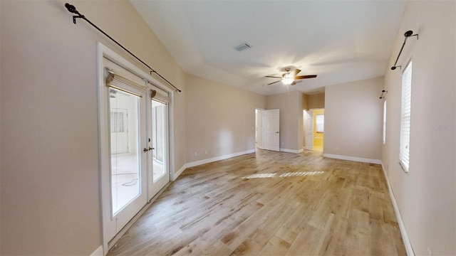 unfurnished room with ceiling fan, light hardwood / wood-style floors, plenty of natural light, and french doors