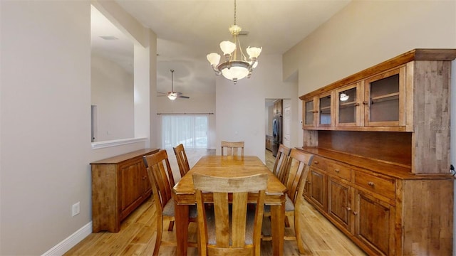 dining space featuring ceiling fan with notable chandelier and light hardwood / wood-style flooring