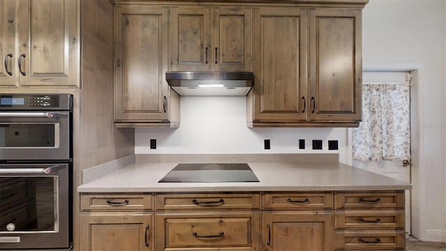 kitchen featuring black electric stovetop and stainless steel double oven