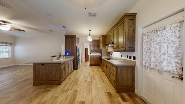 kitchen with ceiling fan, hanging light fixtures, sink, light wood-type flooring, and stainless steel appliances