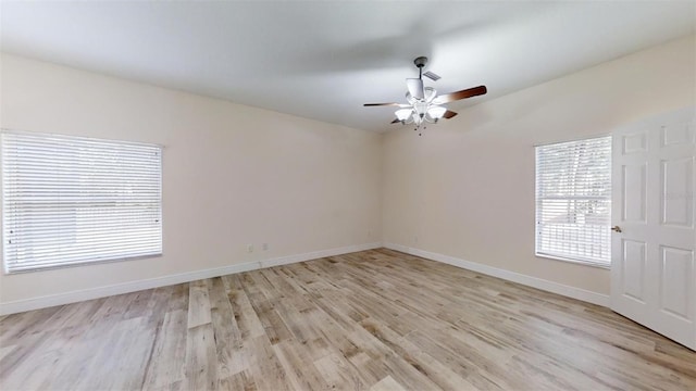 empty room with ceiling fan and light hardwood / wood-style flooring