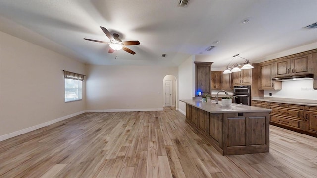 kitchen with black appliances, decorative light fixtures, sink, ceiling fan, and light hardwood / wood-style flooring