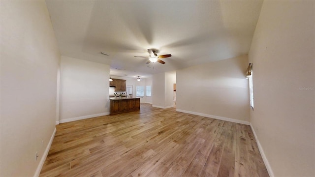 unfurnished living room with light hardwood / wood-style flooring and ceiling fan