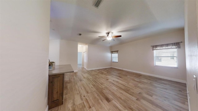 unfurnished living room featuring ceiling fan and light hardwood / wood-style flooring