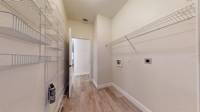 clothes washing area featuring hookup for a washing machine, light hardwood / wood-style flooring, and hookup for an electric dryer