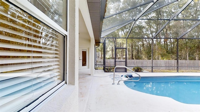 view of pool featuring glass enclosure and a patio area