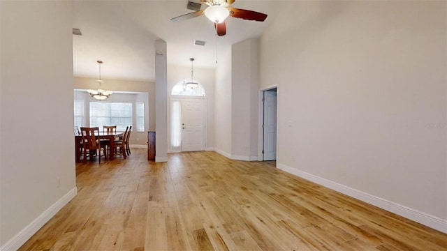 foyer featuring light wood-type flooring and ceiling fan with notable chandelier